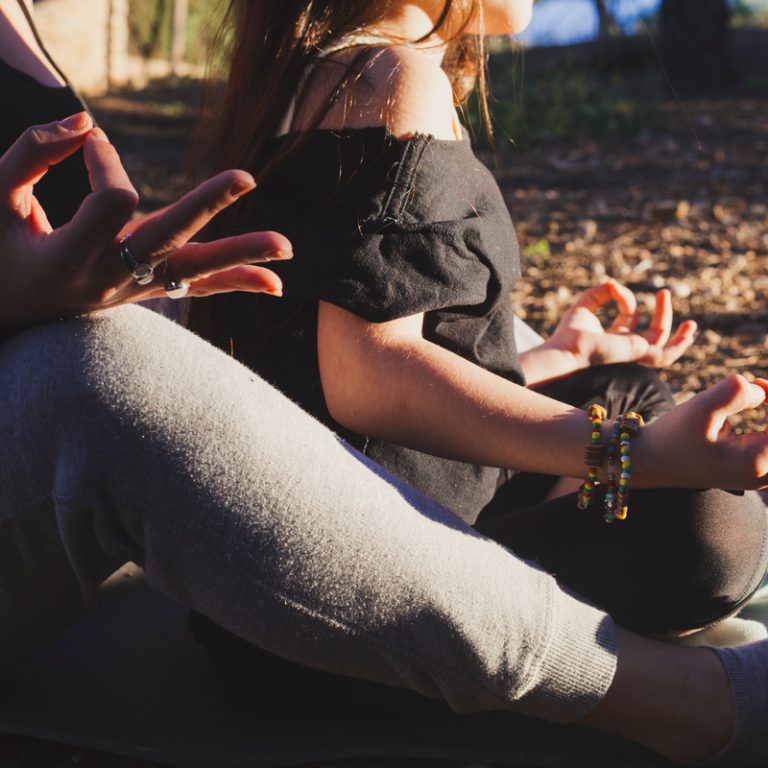 crop-mother-daughter-meditating-park
